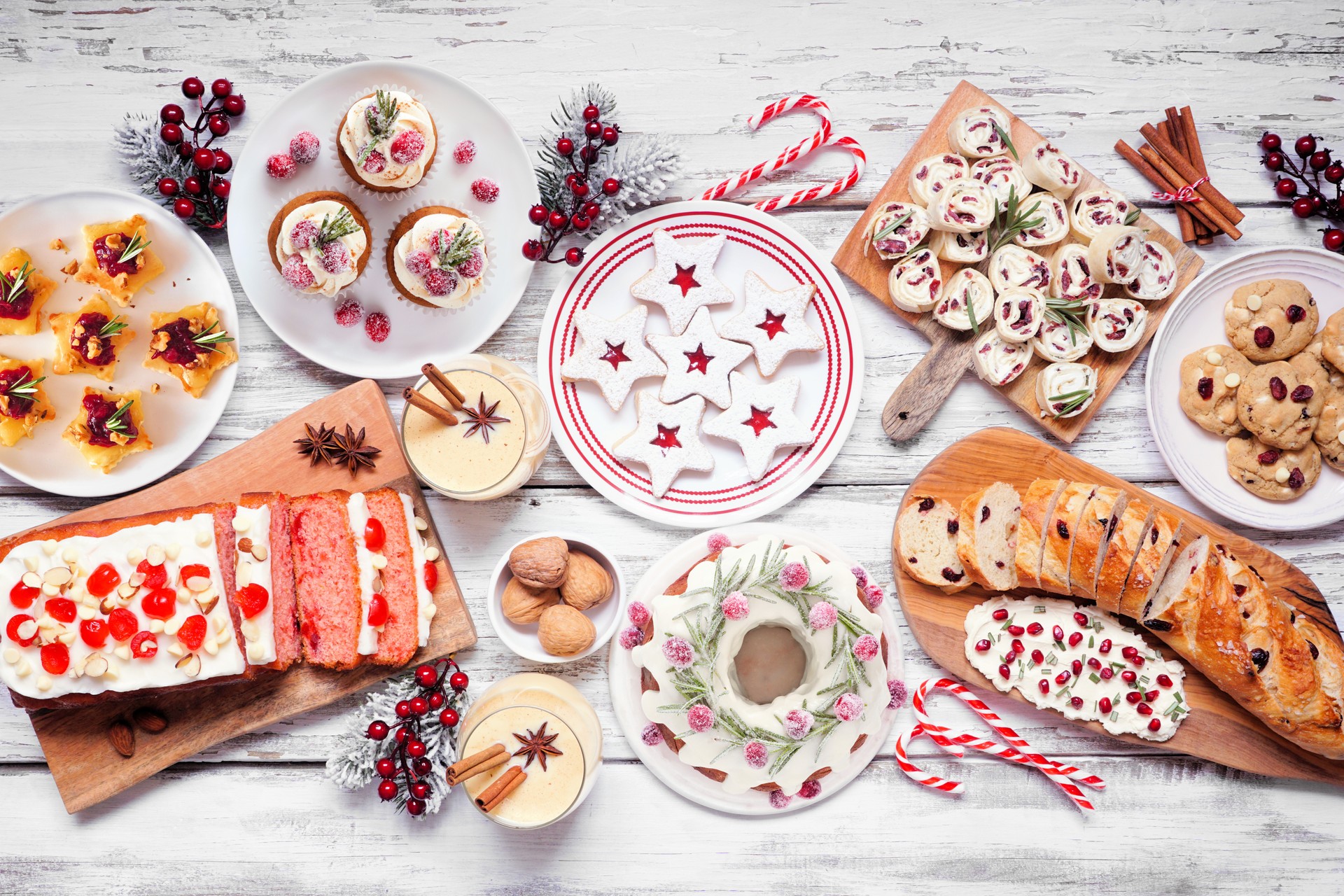 Christmas appetizers and sweet food table scene on a white wood background